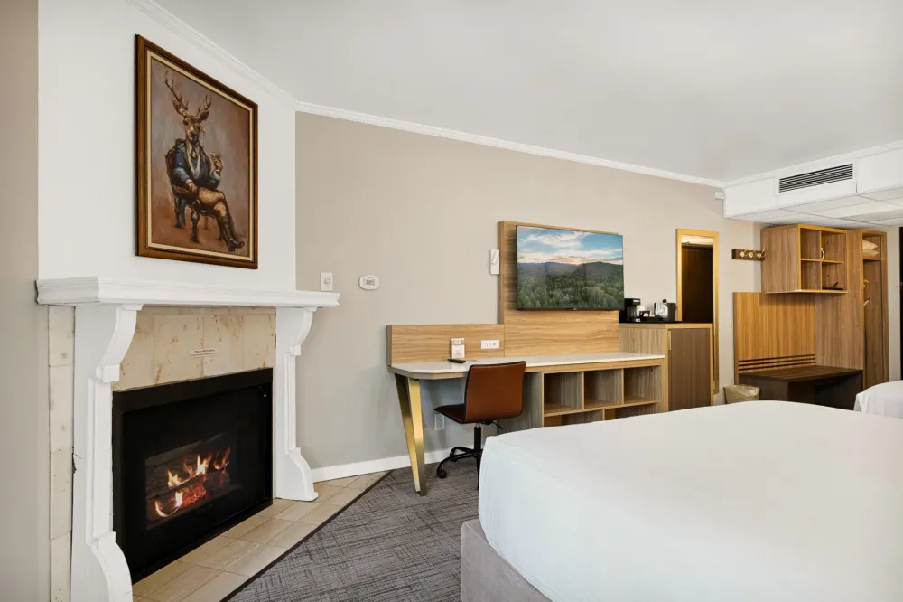 Queen room at Chateau Big Bear with a fireplace and a portrait of a stag in a suit